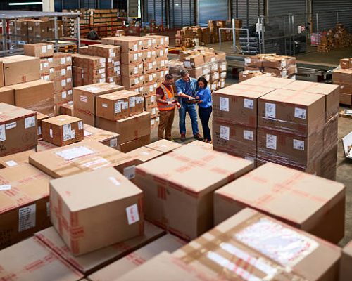 Shot of people at work in a large warehouse full of boxes