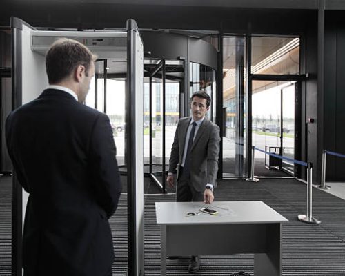 Man at airport security gates putting out phone and keys